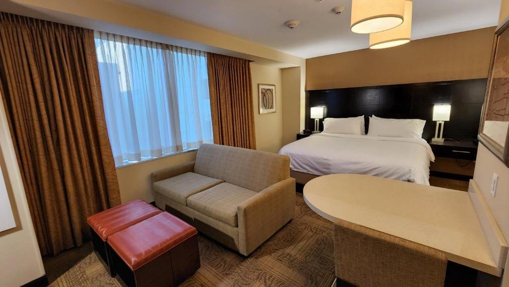 Staybridge Suites Denver Downtown by IHG bedroom with gray sofa and bed
