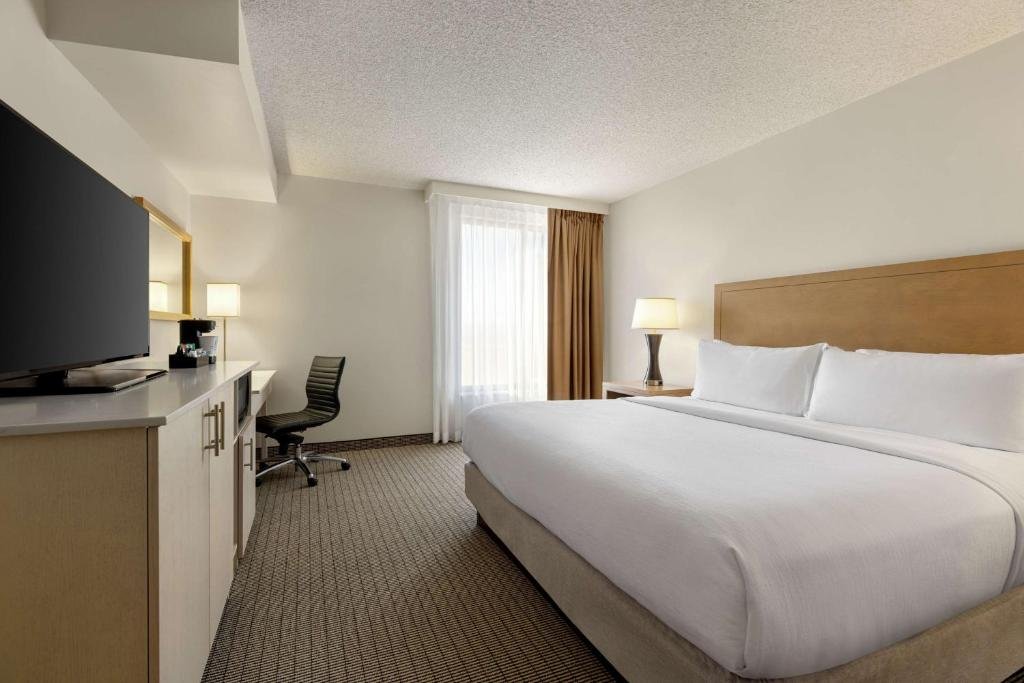 Embassy Suites by Hilton Denver International Airport bedroom with TV