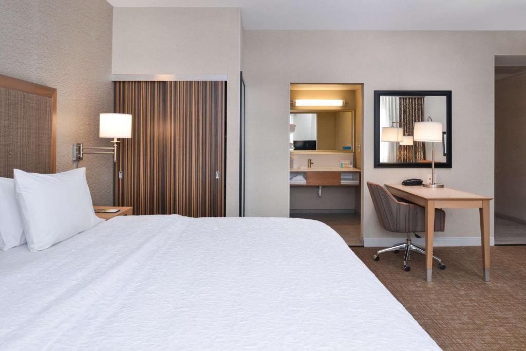 Hampton Inn & Suites Denver-Speer Boulevard bedroom with table and chair