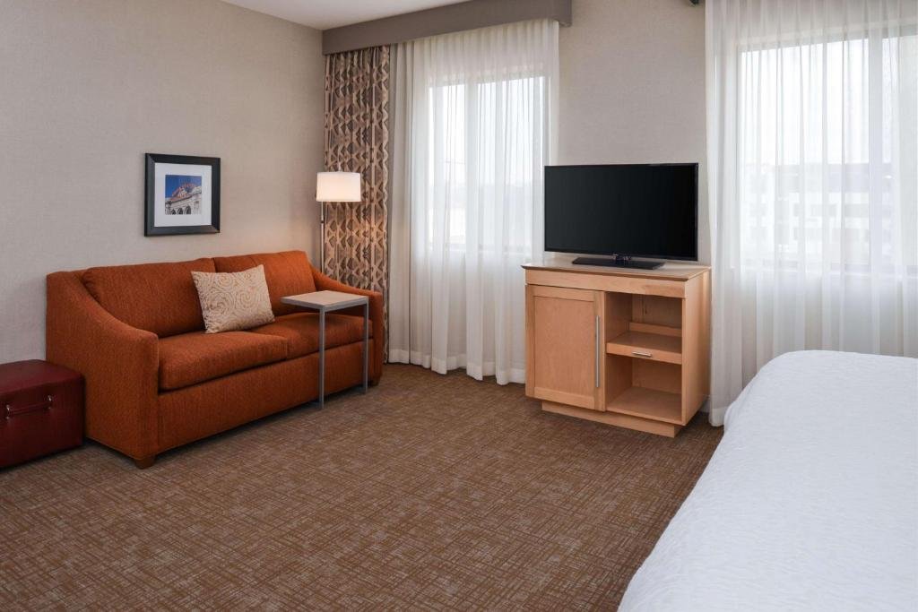 Hampton Inn & Suites Denver-Speer Boulevard room with TV and sofa